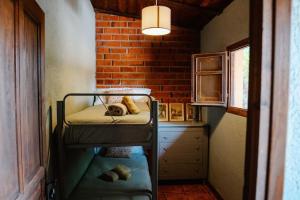a small room with a bunk bed and a brick wall at La Viña. Casa rural en el campo in Tordera