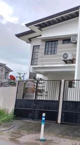 una casa con una puerta azul y una valla en Mando Manor -3 Bedroom Private House for Large Group, en Tacloban
