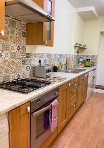 a kitchen with a stove and a sink at ORCHARD HILL HOUSE Apartment in Paignton