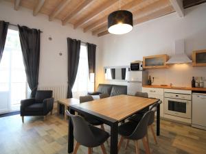 eine Küche und ein Esszimmer mit einem Holztisch und Stühlen in der Unterkunft Charmant Duplex T3 avec Wifi au Centre de Mont-Dore, proche Thermes et Navette Ski Gratuite - FR-1-608-217 in Le Mont-Dore