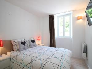 ein weißes Schlafzimmer mit einem Bett und einem Fenster in der Unterkunft Charmant Duplex T3 avec Wifi au Centre de Mont-Dore, proche Thermes et Navette Ski Gratuite - FR-1-608-217 in Le Mont-Dore