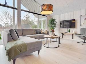 una sala de estar con un sofá y una mesa en Luxury Retreat with Pool - By Traum Ferienwohnungen, en Bøtø By