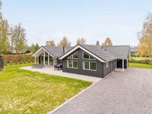 una casa con techo negro y patio en Luxury Retreat with Pool - By Traum Ferienwohnungen, en Bøtø By
