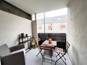 Le Verrières - Appartement Cozy avec balcon proche de la gare في كليرمون فيران: بلكونه فيها طاوله وكراسي ومبنى