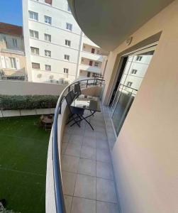 a balcony with a table and chairs on a building at Appartement Centre Ville Sainte-Maxime Tout à Pied in Sainte-Maxime