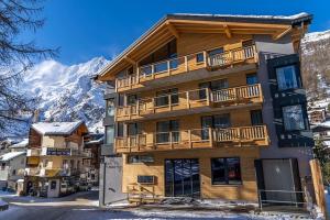 a apartment building with a balcony on a mountain at Saas-Fee stylish ski apartment in Saas-Fee
