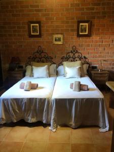two twin beds in a room with a brick wall at Casa rural en el campo LAS DALIAS in Tordera +5 photos