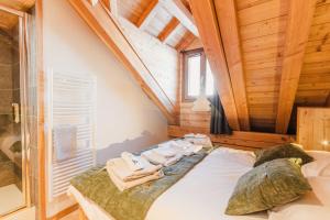a bedroom with a bed with towels on it at Les Loups Blancs, duplex rénové en 2022, pied des pistes in Montgenèvre