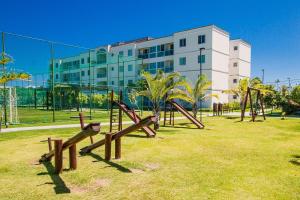 a park with a bunch of playground equipment in front of a building at Apartamento Frente Piscina Térreo no Palm Village em Porto de Galinhas - Eco11 in Porto De Galinhas