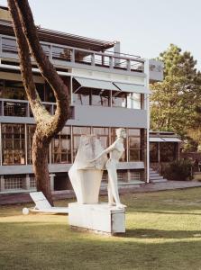 eine Statue im Gras vor einem Gebäude in der Unterkunft Vintage Hotel Parque do Rio in Esposende