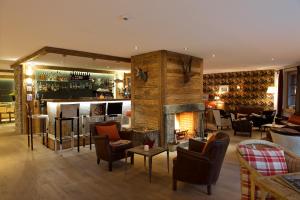 a living room with a fireplace and a bar at Matterhorn Lodge Boutique Hotel & Apartments in Zermatt