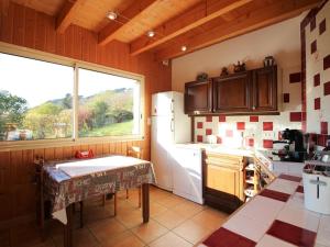 a kitchen with a table and a white refrigerator at Mont-Dore : Chalet spacieux avec parking et grand terrain - FR-1-608-106 in Le Mont-Dore +11 photos