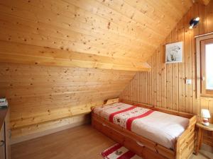 a log cabin with a bed in a room at Mont-Dore : Chalet spacieux avec parking et grand terrain - FR-1-608-106 in Le Mont-Dore