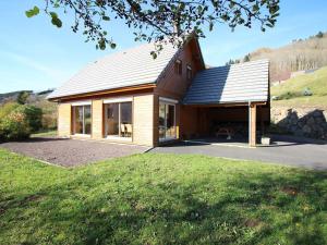 a house with a metal roof on top of a yard at Mont-Dore : Chalet spacieux avec parking et grand terrain - FR-1-608-106 in Le Mont-Dore