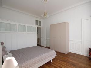a bedroom with a bed and white walls and wood floors at Appartement Mont-Dore, 2 pièces, 4 personnes - FR-1-608-108 in Le Mont-Dore