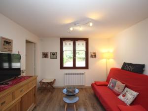 a living room with a red couch and a tv at Appartement Mont-Dore, 2 pièces, 4 personnes - FR-1-608-114 in Le Mont-Dore