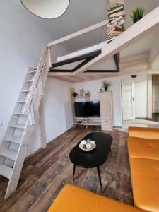 Sala de estar con cama elevada y mesa en Nemuno Apartamentai en Kaunas