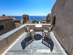 a patio with two chairs and a table on a balcony at Κyma Mansion in Monemvasia in Monemvasia