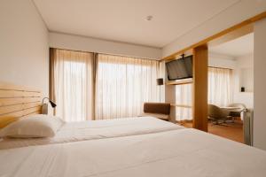 a hotel room with a bed and a television at Parque do Rio Hotel in Esposende