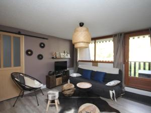 a living room with a couch and a table and chairs at Appartement Mont-Dore, 2 pièces, 4 personnes - FR-1-608-142 in Le Mont-Dore