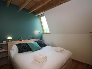 ein Schlafzimmer mit einem großen weißen Bett mit einem Fenster in der Unterkunft Charmant Duplex T3 au Mont-Dore, à 300m des Thermes, avec Parking et WiFi ! - FR-1-608-151 in Le Mont-Dore