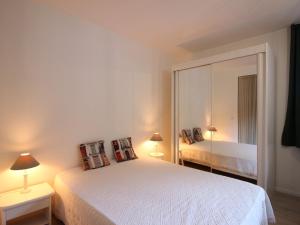 ein Schlafzimmer mit einem weißen Bett und einem großen Spiegel in der Unterkunft Appartement Mont-Dore, 2 pièces, 6 personnes - FR-1-608-175 in Le Mont-Dore