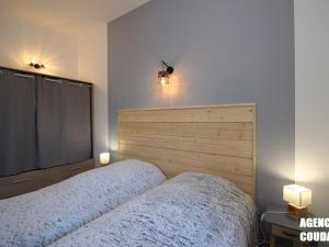 ein Schlafzimmer mit einem Bett und einem großen Bildschirm in der Unterkunft LA BOURBOULE CENTRE - Beau T2 rénové, wifi et cuisine équipée - FR-1-608-159 in La Bourboule