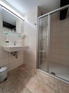 ein Bad mit einer Dusche und einem Waschbecken in der Unterkunft Hotel Gasthof Kohlmayr in Gmünd in Kärnten