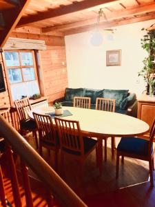 a dining room with a table and chairs and a couch at Vila Kopa Nida in Nida