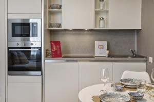een keuken met witte kasten en een tafel met een magnetron bij Comfort studio in Brignole de Ferrari by Wonderful Italy in Genua