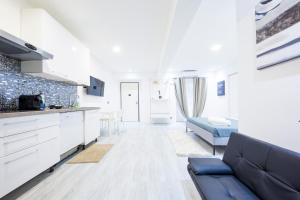 ジェノヴァにあるScirocco House by HolidayHome24のソファとキッチンのあるリビングルーム +5枚の写真