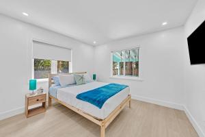 a white bedroom with a bed and two windows at Quiet and secluded 4 bedroom home! in Fort Lauderdale +28 photos