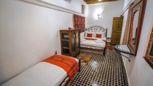 a bedroom with a bed and a chair in it at Riad Green House in Fès
