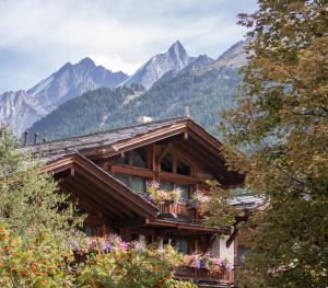 uma casa com varanda e montanhas ao fundo em Matterhorn Lodge Boutique Hotel & Apartments em Zermatt