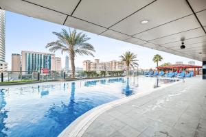 una gran piscina con sillas azules y palmeras en Breathtaking sea-view condo in Dubai Marina - Palm Views! en Dubái