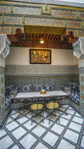 a room with a table and chairs and a ceiling at Riad Green House in Fès