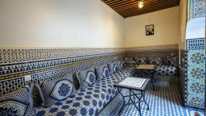 a room with blue and white patterned seats in a restaurant at Riad Green House in Fès