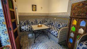 a corner of a room with a table and chairs at Riad Green House in Fès