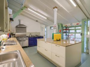 a large kitchen with white cabinets and a sink at Lower Treginnis Farm in St. Davids