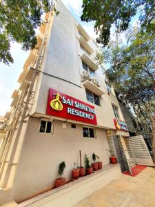 班加羅爾的住宿－Sai Shreyas Residency, Best Hotel near Bangalore Airport，植物建筑的一侧的标志