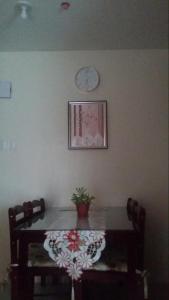 uma mesa de jantar com um vaso de plantas e um relógio na parede em Rochester Condo em Manila
