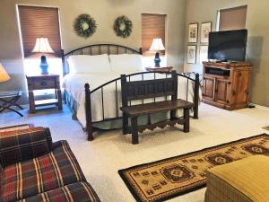 sypialnia z łóżkiem, telewizorem i kanapą w obiekcie Inn at Indian Creek w mieście Burton