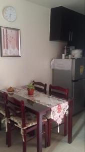 a kitchen with a table and two chairs and a clock at Rochester Condo in Manila