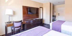 a hotel room with a desk with a tv and a bed at Red Garter Hotel & Casino by Red Lion Hotels in West Wendover