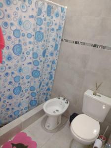 een badkamer met een toilet en een douchegordijn bij Quinta Lo de Fran in Arana