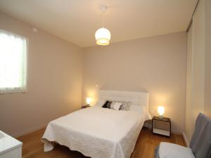 ein Schlafzimmer mit einem weißen Bett und zwei Lampen in der Unterkunft Appartement Mont-Dore, 3 pièces, 6 personnes - FR-1-608-13 in Le Mont-Dore
