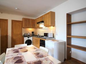a kitchen with a table and a stove top oven at Appartement T3 avec Parking à La Bourboule, à 500m des Thermes et du Centre, WiFi Inclus - FR-1-608-14 in La Bourboule +6 photos