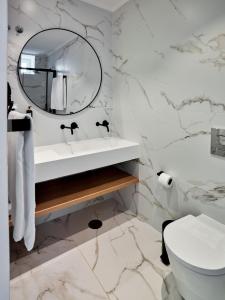 uma casa de banho branca com um lavatório e um espelho em The Bastion Elvas Apartments em Elvas