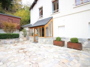 a house with a stone patio in front of it at Appartement T3 avec Parking à La Bourboule, à 500m des Thermes et du Centre, WiFi Inclus - FR-1-608-14 in La Bourboule
