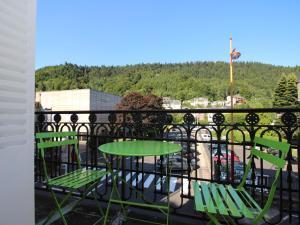 ein Balkon mit einem grünen Tisch und Stühlen darauf in der Unterkunft Hyper Centre Mont-Dore: T3 spacieux avec balcon et WiFi, à côté des Thermes - FR-1-608-23 in Le Mont-Dore + 9 Fotos